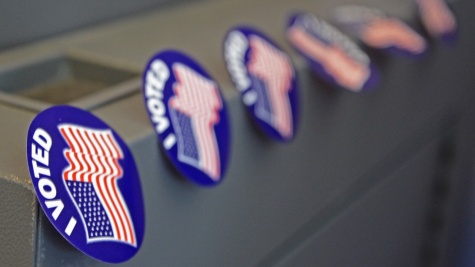 A line of "I voted" stickers with American flags line the corner of a file cabinet