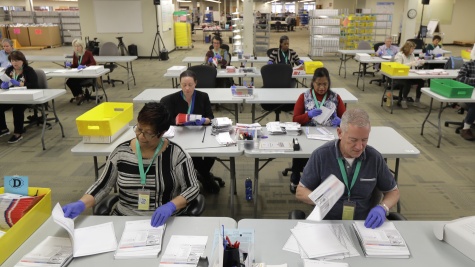 A room full of election workers processing ballots. 