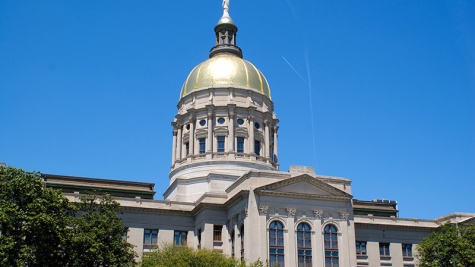 A picture of the golden dome of the Georgia state capitol against a blue summer sky.