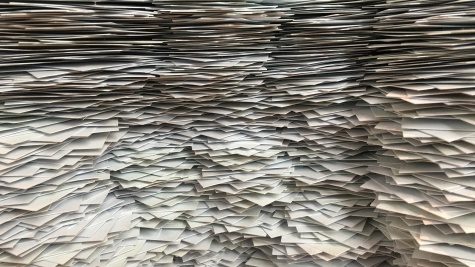 Stacks of paper are piled high, blocking the whole screen.