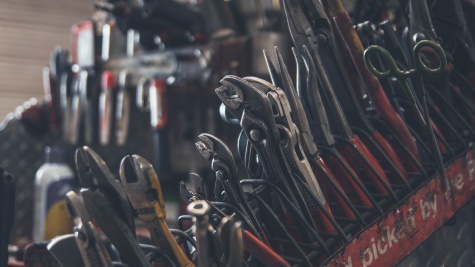 A well-used, greasy row of tools: wrenches, pliers, and the like.