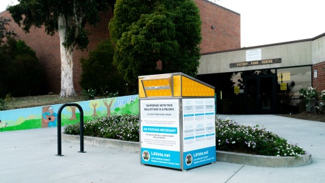 A drop box for ballots in front of a brick building.