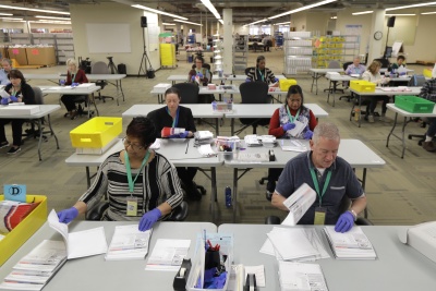 A room full of election workers processing ballots. 