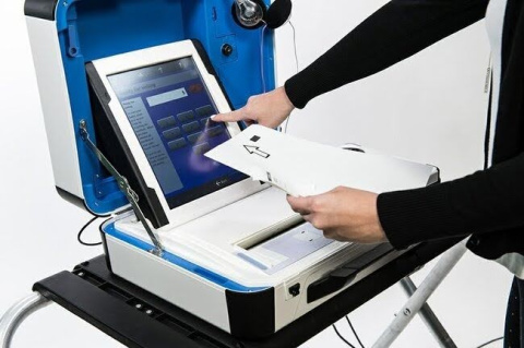 Hand-fed optical scanner produced by Hart Intercivic. Voters insert their paper ballot into the scanner and then use the screen to verify there are no issues with their ballot. Once verified, the machine tabulates the ballot and deposits it into its integrated ballot box. Election officials receive tabulation reports from each machine at the close of polls. Image provided by Hart Intercivic.